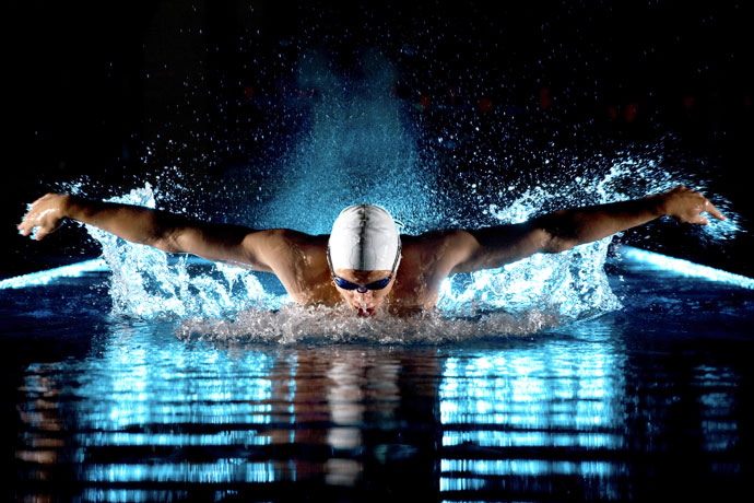 A butterfly swimmer shot at night in a pool