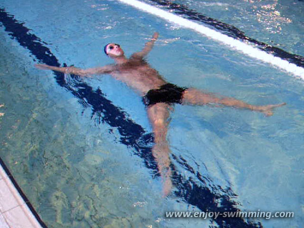 A man swimming elementary backstroke