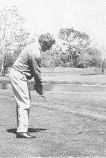 Black-and-white photo of golfing stance from the back of the swing