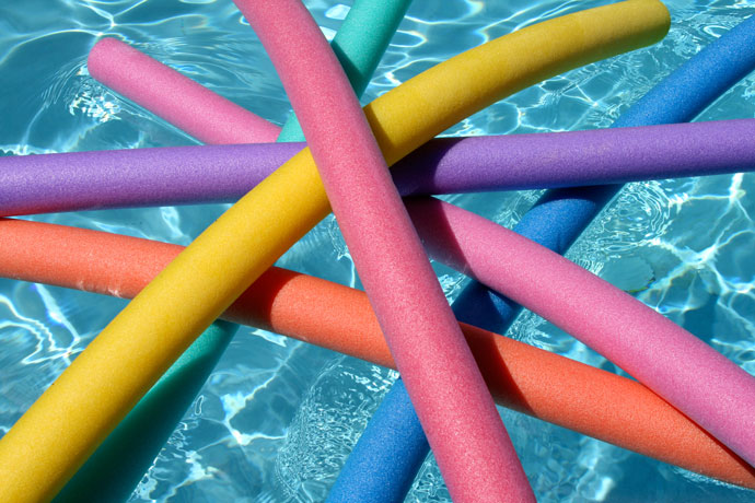 A few water noodles floating on the water surface