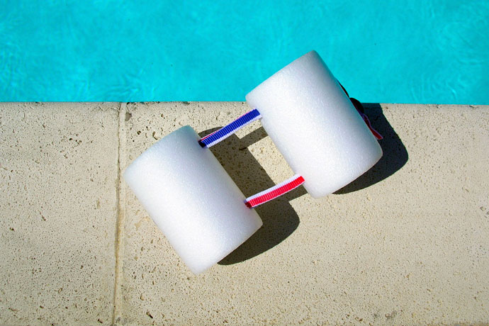 A two-piece pull buoy lying at the poolside
