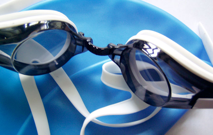 Some swimming gear: a blue swim cap and swim goggles