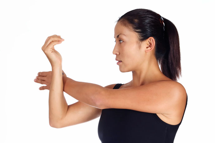 A woman stretching one of her shoulders