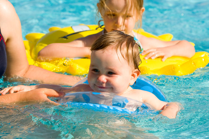 A happy baby attending a swimming lesson