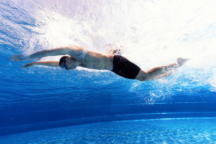 A butterfly stroke swimmer seen from underwater