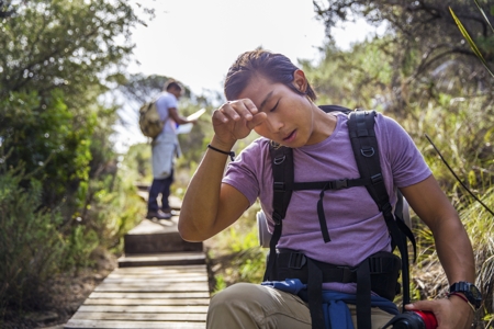 Hiker wiping sweat from forehead