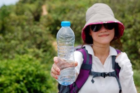 Hiking woman holding bottle of water