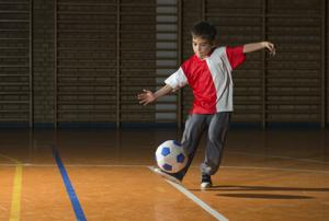 boy kicking football